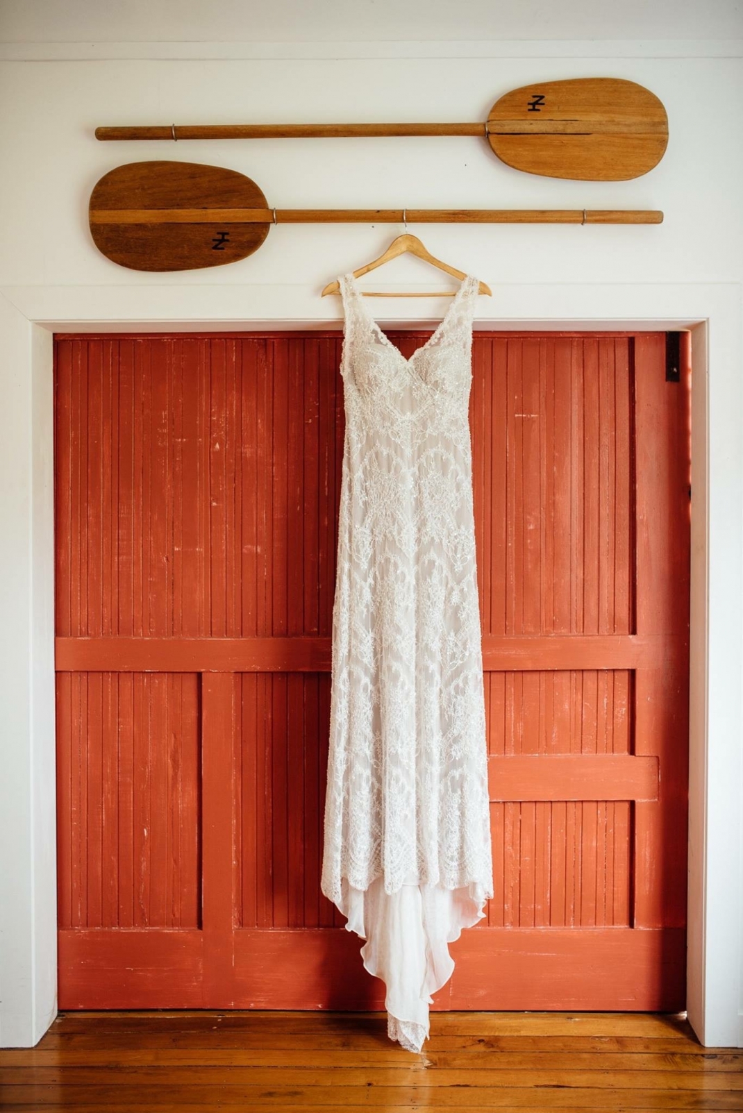 Wedding gown hanging in the doorway od the barn