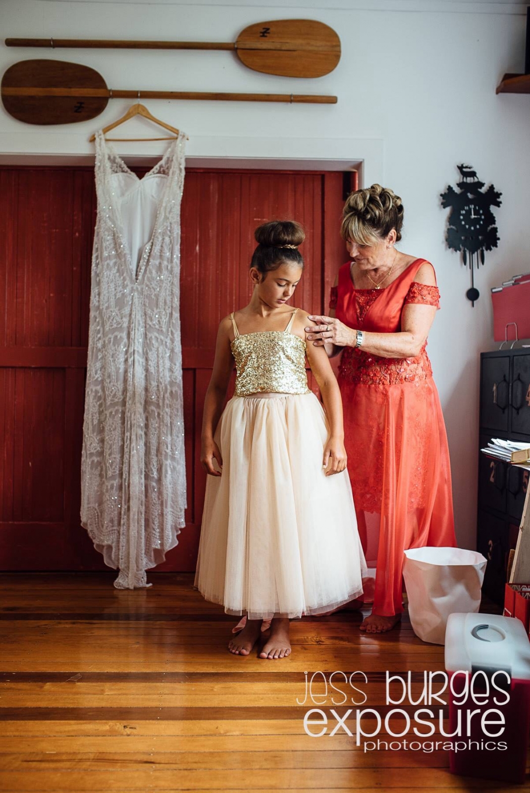 Mother and daughter of bride standing next to gown hanging in the barn doorway, hair Laurel Stratford hairstylist