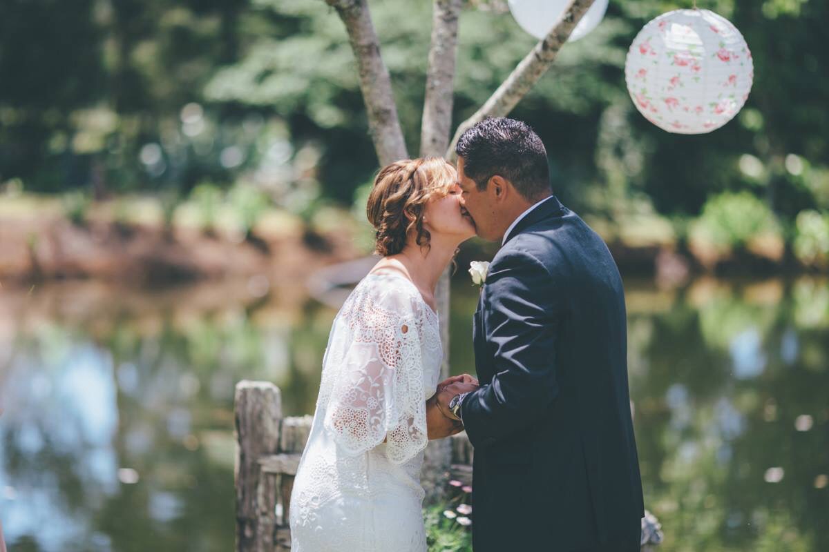 The bride & groom kissing in the garden. Kerikeri, NZ. HAIR Laurel Stratford Hairstylist