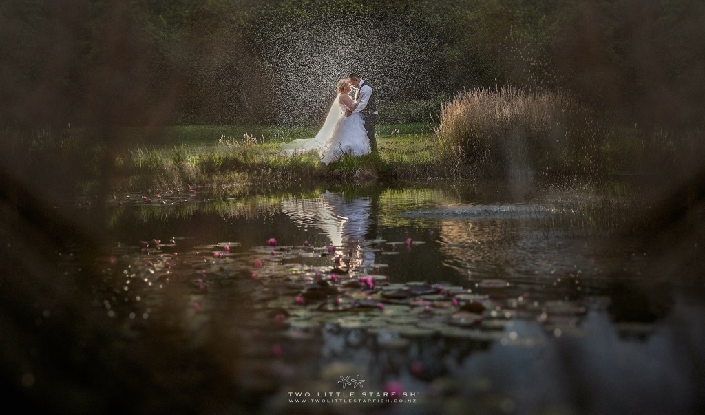 bride & groom by the lake in the rain, Kerikeri wedding, bridal hair Laurel Stratford