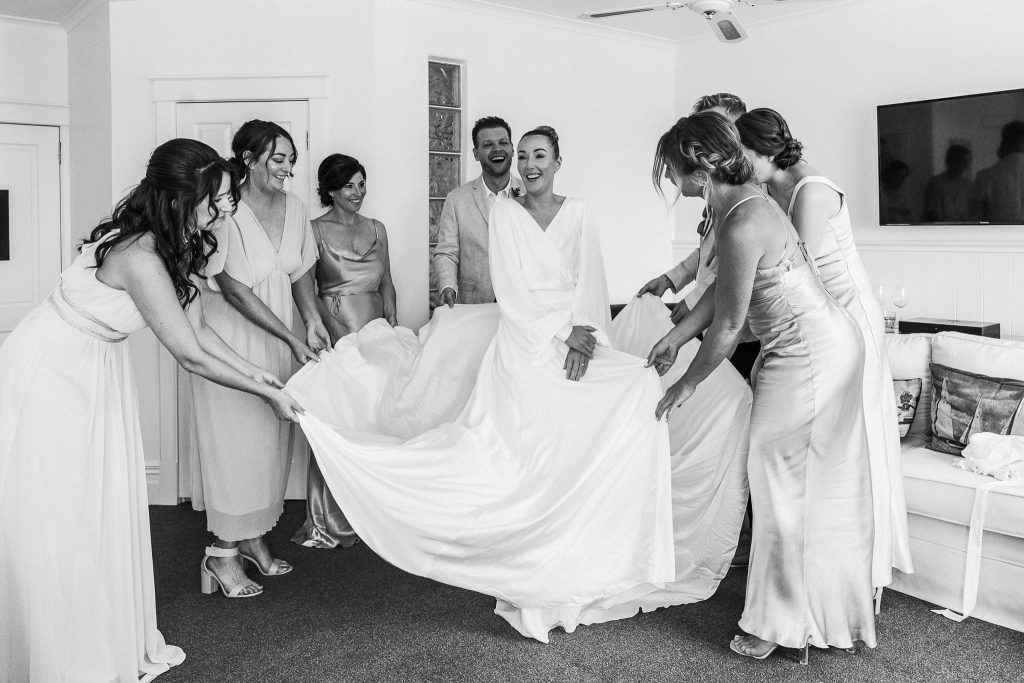 Bride with Bridesmaid showing dress off